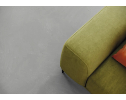 Ein grauer Boden und ein grünes Sofa sind zu sehen.
