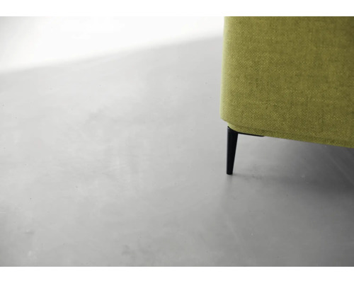 Detailansicht eines grünen Sofas mit schwarzen Füßen.