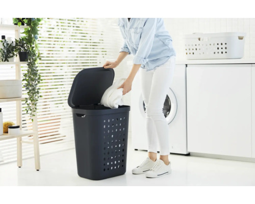 Wäschekorb mit Deckel in einem hellen Badezimmer mit Waschmaschine