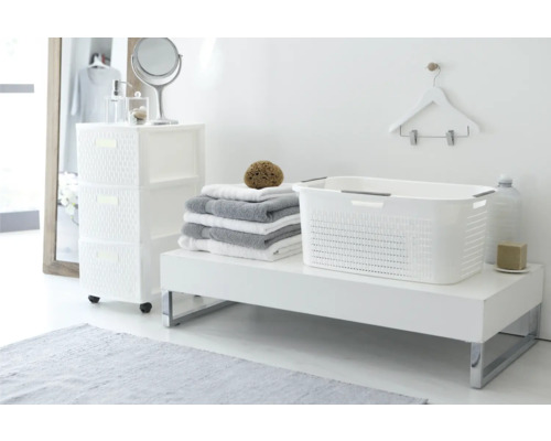 Intérieur de salle de bains avec panier à linge en plastique blanc, serviettes et commode