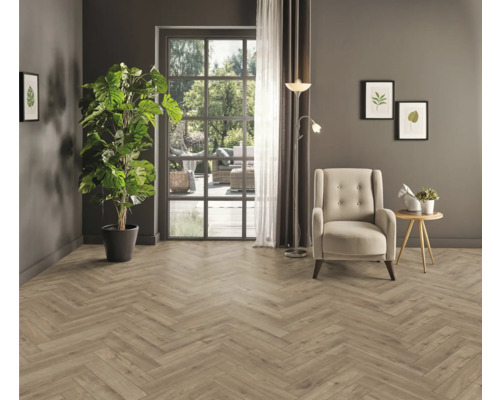 Salon avec parquet en chevrons, fauteuil, lampadaire et plante d''intérieur