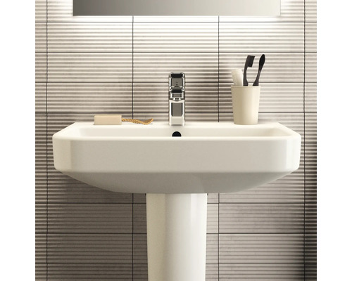 Lavabo avec robinet, savon, brosses à dents et gobelet à brosses à dents dans la salle de bain