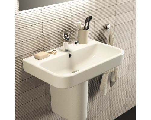 Lavabo avec robinet, savon, brosses à dents et serviette dans la salle de bain