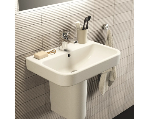 Lavabo de salle de bains moderne avec robinet, savon, brosse à dents et serviette.