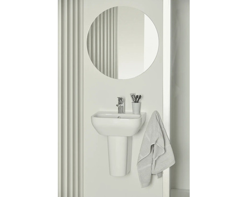 Badezimmer mit Aufsatzwaschbecken, Armatur, rundem Spiegel und Handtuch