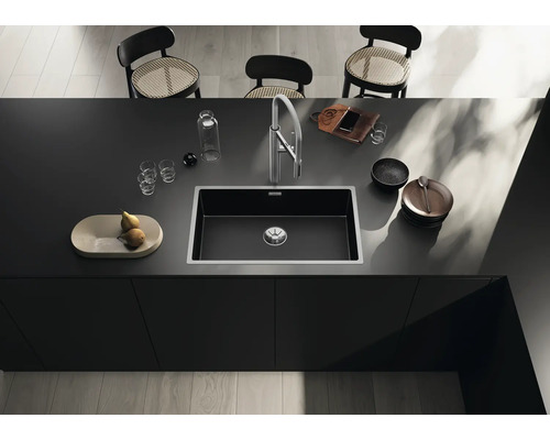 Spüle in einer modernen Kücheninsel mit Armatur, Geschirr und Dekoration