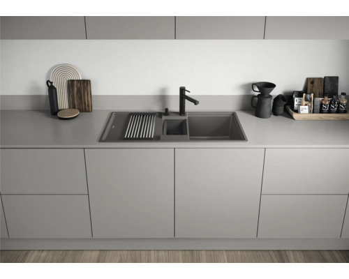 Küchenspüle aus Granit mit Abtropffläche und Spültischarmatur auf einer Küchentheke