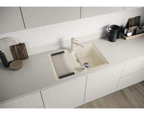 Küchenspüle mit Abtropfgestell, Wasserhahn und Zubehör auf einer Küchentheke.