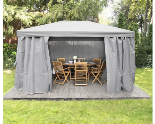 Pavillon mit Vorhängen und Gartenmöbeln auf einer Terrasse im Garten
