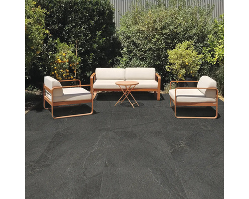 Terrasse avec coin salon et dalles de sol sombres à l''extérieur.