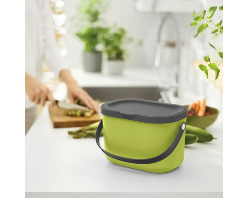 Seau à compost vert avec couvercle sur un comptoir de cuisine