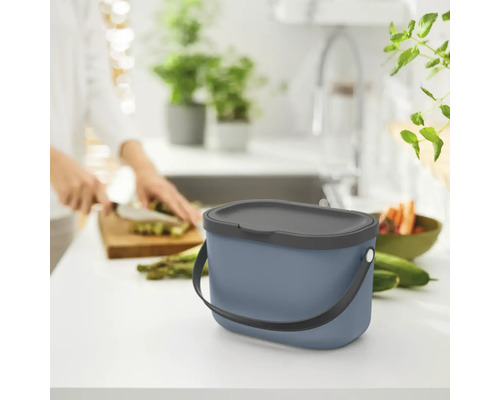 Scène de cuisine avec une poubelle à déchets organiques sur un plan de travail