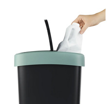 Poubelle avec couvercle à charnière et main jetant une bouteille en plastique à l''intérieur