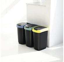 Trois poubelles noires avec couvercles colorés pour le tri des déchets
