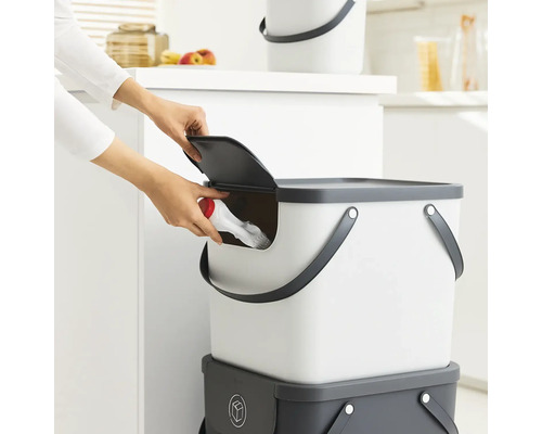 Personne jette un objet dans un seau avec couvercle