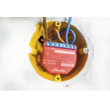 Logo Shelly dans un boîtier d''encastrement jaune avec des câbles