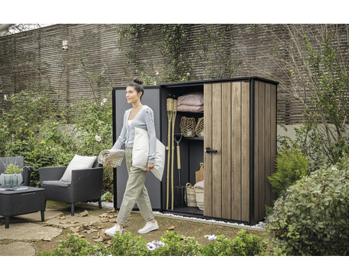 Scène de jardin avec une femme devant une remise à outils contenant des outils de jardin et des meubles de jardin