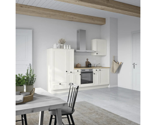 Cuisine claire avec armoires blanches et plan de travail en bois, table à manger et chaise au premier plan
