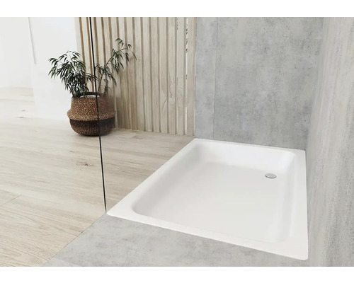 Rechteckige Duschwanne in einem hellen Badezimmer mit Pflanze im Korb