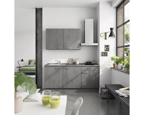 Cuisine moderne avec des armoires grises, une hotte aspirante et un évier dans une pièce lumineuse.