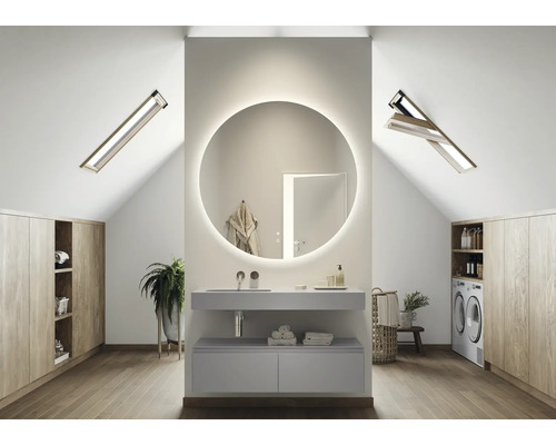 Modernes Badezimmer im Dachgeschoss mit rundem Spiegel, Waschtisch, Waschmaschine und Dachfenstern.