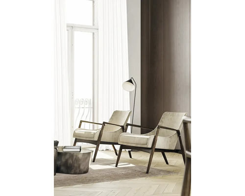 Zwei Sessel mit Holzrahmen und Stehleuchte in einem hellen Wohnzimmer.