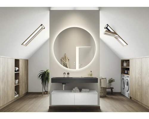 Salle de bains lumineuse dans les combles avec lavabo, miroir, placards intégrés et fenêtres de toit
