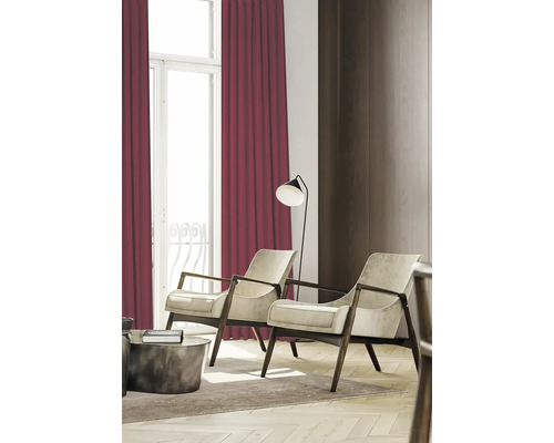 Wohnzimmer mit zwei Sesseln, Stehlampe und bordeauxroten Vorhängen