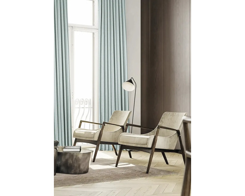 Helle, freundliche Inneneinrichtung mit Vorhängen, Sesseln und Stehleuchte