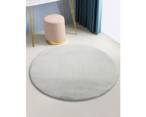 Tapis rond et moelleux dans un intérieur avec tabouret et table