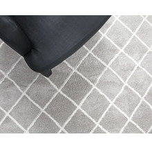Tapis gris à motif losanges et une partie d''un fauteuil