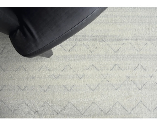Gros plan d''un tapis à motifs géométriques et d''un pied de chaise