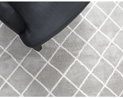 Teppich mit Rautenmuster neben Sessel