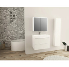 Badezimmer mit Waschtisch, Spiegelschrank, Hochschrank und Badewanne vor einer Wand mit Pflanzenmuster