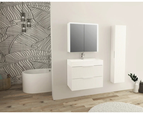 Badezimmer mit Waschtisch, Spiegelschrank, Hochschrank und Badewanne vor einer Wand mit Pflanzenmuster