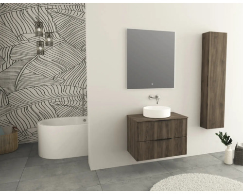 Salle de bains moderne avec baignoire, meuble-lavabo avec miroir, armoire suspendue et plantes.