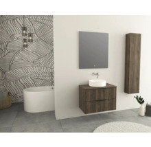 Badezimmer mit Waschtisch, Spiegel, Hängeschrank und Badewanne vor einer Tapete mit Blattmuster