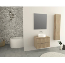 Badezimmer mit Waschtisch, Spiegel, Hochschrank und Badewanne vor Blattmuster-Tapete