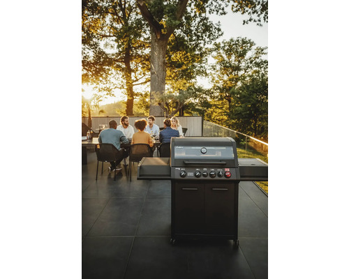 Barbecue à gaz avec des personnes dans le jardin