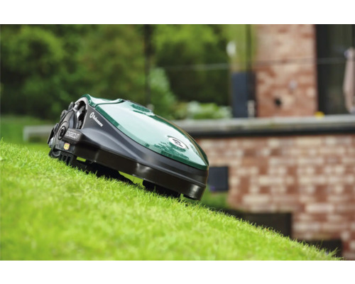 Robot tondeuse sur pelouse devant une maison