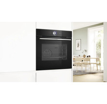 Einbau-Backofen in einer modernen Küche mit Esstisch im Hintergrund.