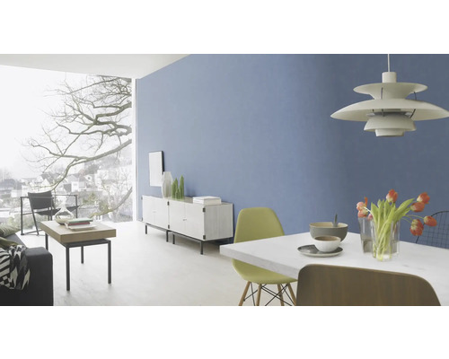 Helles Wohnzimmer mit blauer Wand, Esstisch, Stühlen, Sideboard und großem Fenster