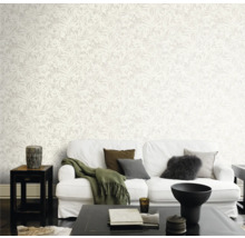 Salon lumineux avec papier peint à motifs, canapé blanc et table basse foncée