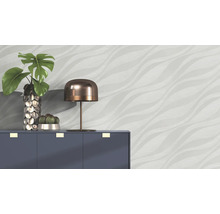 Scène avec commode, lampe, vase avec plante et papier peint à motif ondulé