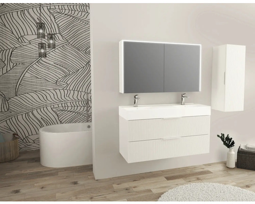 Salle de bains moderne avec meuble-lavabo, armoire de toilette, armoire haute et baignoire devant un papier peint à motifs