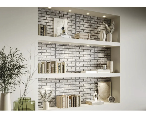 Décoration murale décorative avec panneaux de pierre dans une étagère de salon avec des livres et des vases