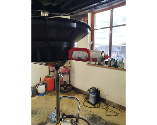 Récupérateur d''huile avec bac de récupération et bombe de nettoyant dans un atelier.