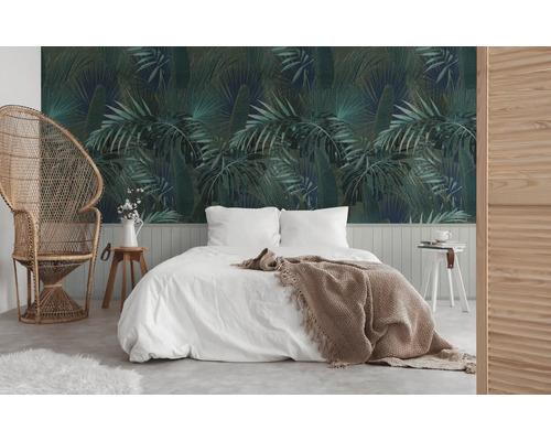 Chambre avec papier peint botanique, lit et fauteuil en rotin