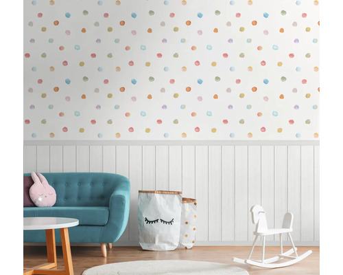 Kinderzimmer mit Wandtapete mit bunten Punkten, Sofa und Spielzeug