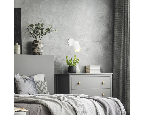Chambre avec lit, commode et applique murale blanche